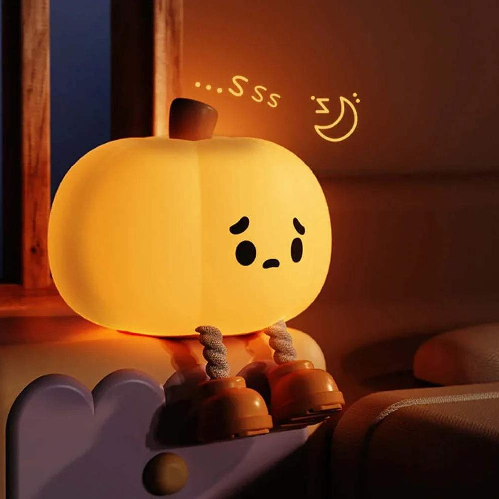 Cute Pumpkin Night Light with a sleeping expression on a soft surface.
